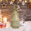 The vintage tower shaped glass Christmas tree glowing on a table