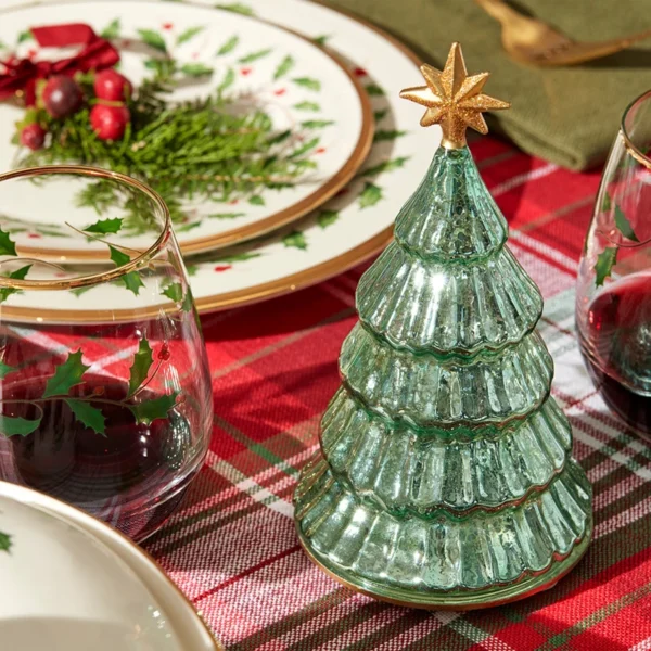 There is a star lit pine tree glass Christmas tree on the table