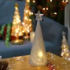 The LED light changing glass Christmas tree glowing on a Christmas table