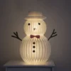 The kraft paper Snowman Christmas ornament glowing in the night