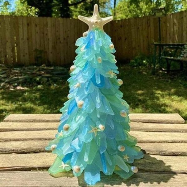 There is a sea glass Christmas tree on the sunshine shining its lights