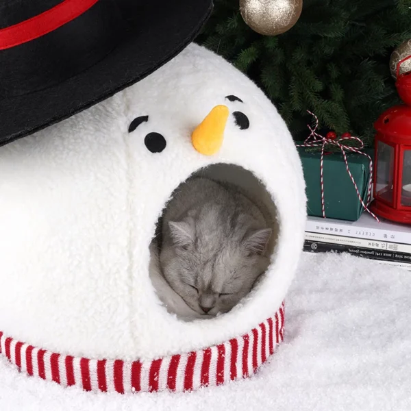 There is a cat sleeping inside the Snowman cat Christmas house ornament