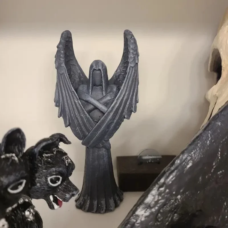 There is a black fallen angel statue on the bookshelf