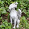 There is a dog angel statue in the garden.