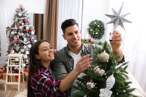 A man and woman are selecting the perfect Christmas tree topper