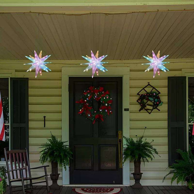 There are three Moravian Star Tree Toppers hanged on the porch