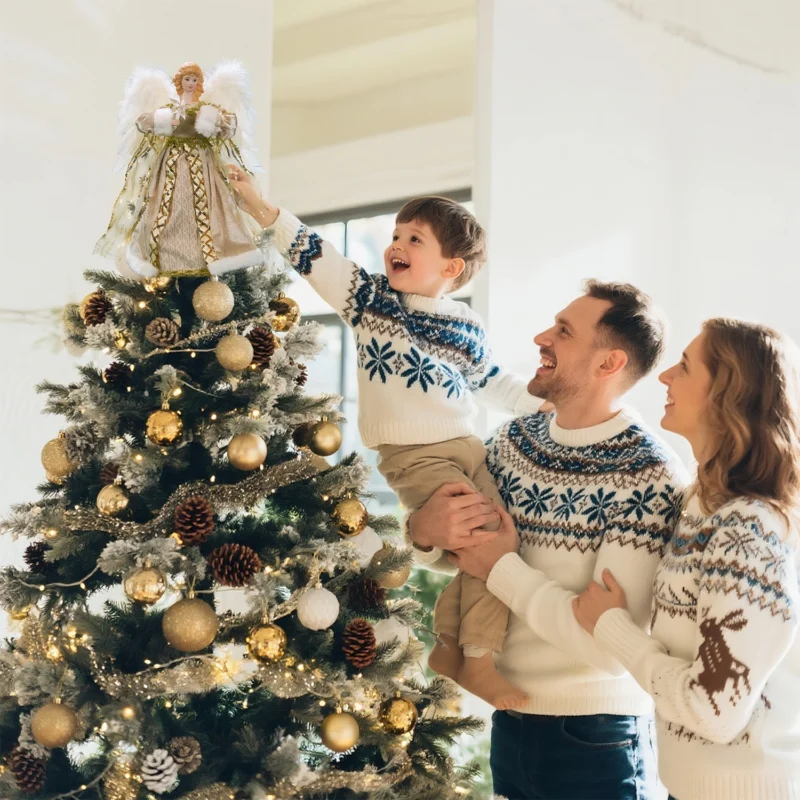 Heartwarming Christmas moment: father helps boy put angel tree topper while mother looks on smiling
