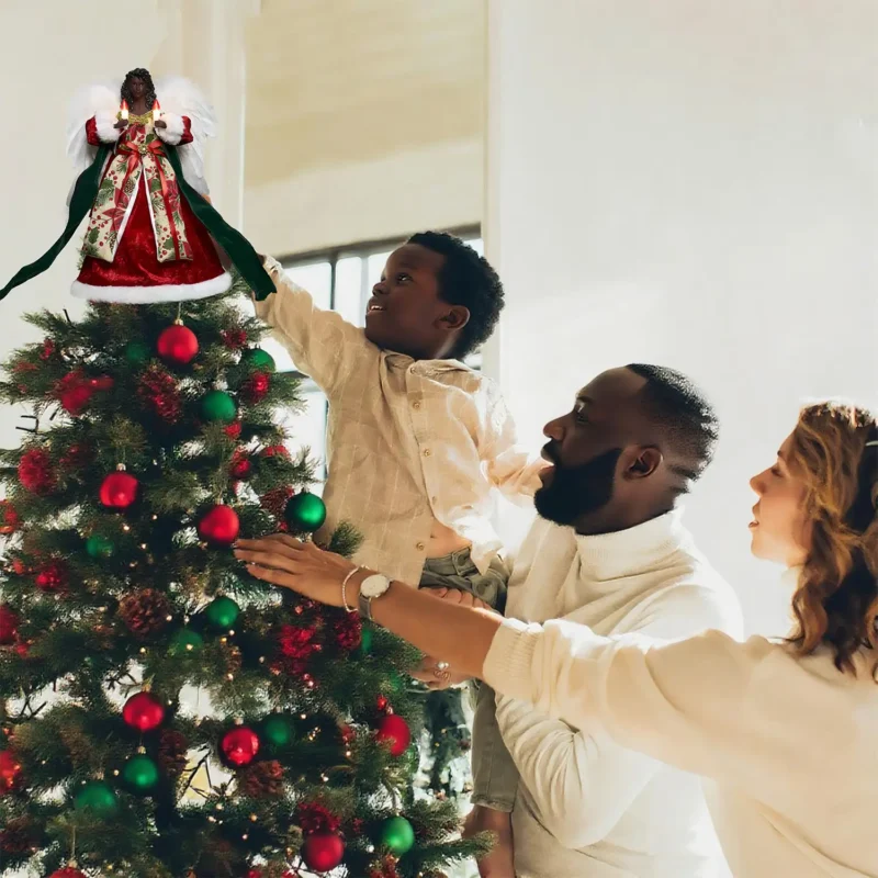 Heartwarming Christmas moment: father helps boy put a red black angel tree topper while mother looks on smiling