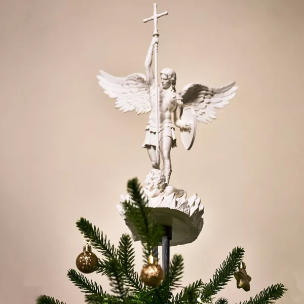 A white biblically accurate saint michaels archangel angel tree topper on top of a lighted Christmas tree