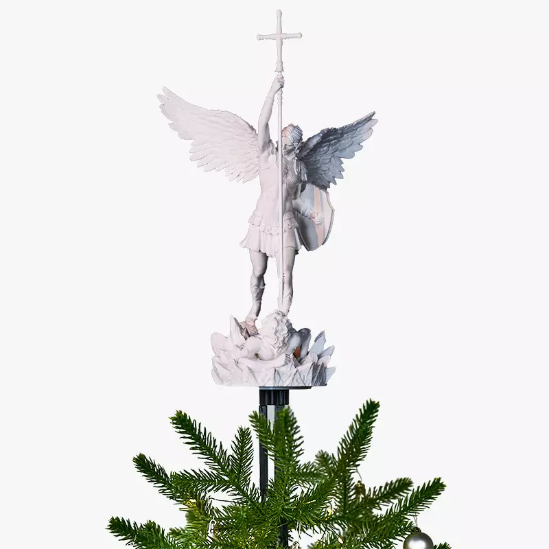 A white biblically accurate saint michaels archangel angel tree topper on top of a Christmas tree