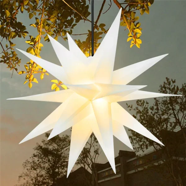 A white lighting Moravian treetop star hangs from a tree