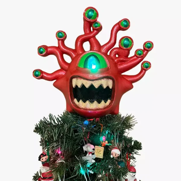 A red biblically beholder tree topper​ on top of a Christmas tree