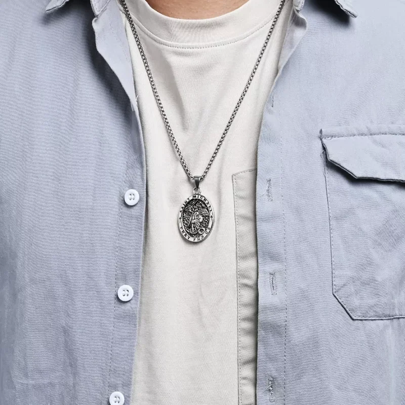 A man is wearing a silver Saint Michael necklace on a luxury box.