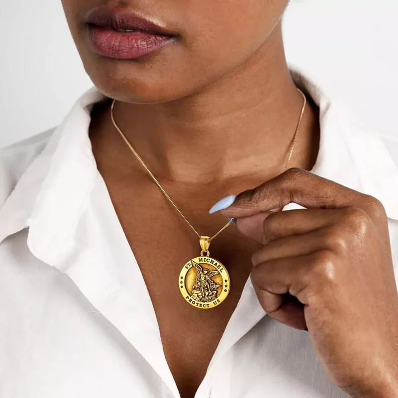 A woman is wearing a gold saint michael the archange necklace