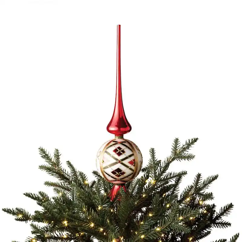 A red finial tree topper on a Christmas tree