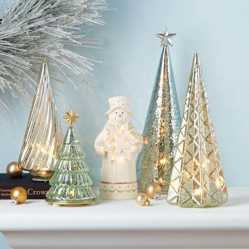 There are four glass Christmas tree on the desk