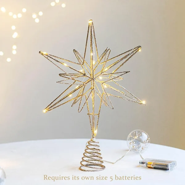 A gold glowing Christmas star treee topper stands on the table.