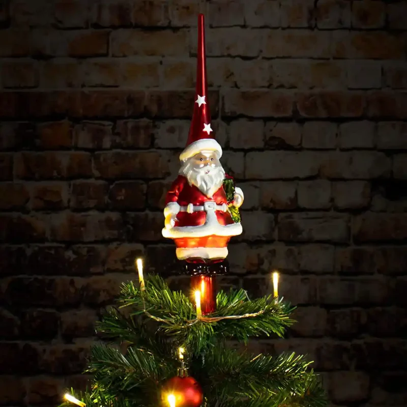 A glass finial tree topper with Santa Claus stands on the tree.